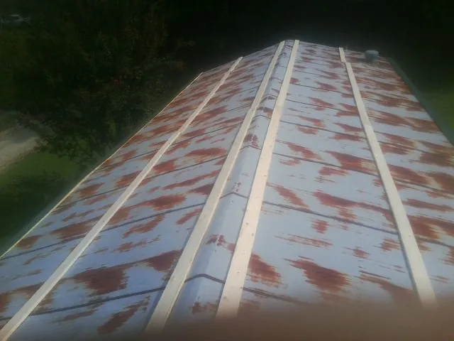 Rusted metal roof panels with new wood purlins before replacement — Storm Damage Roof Repair in Boulder City by Roofing Brothers